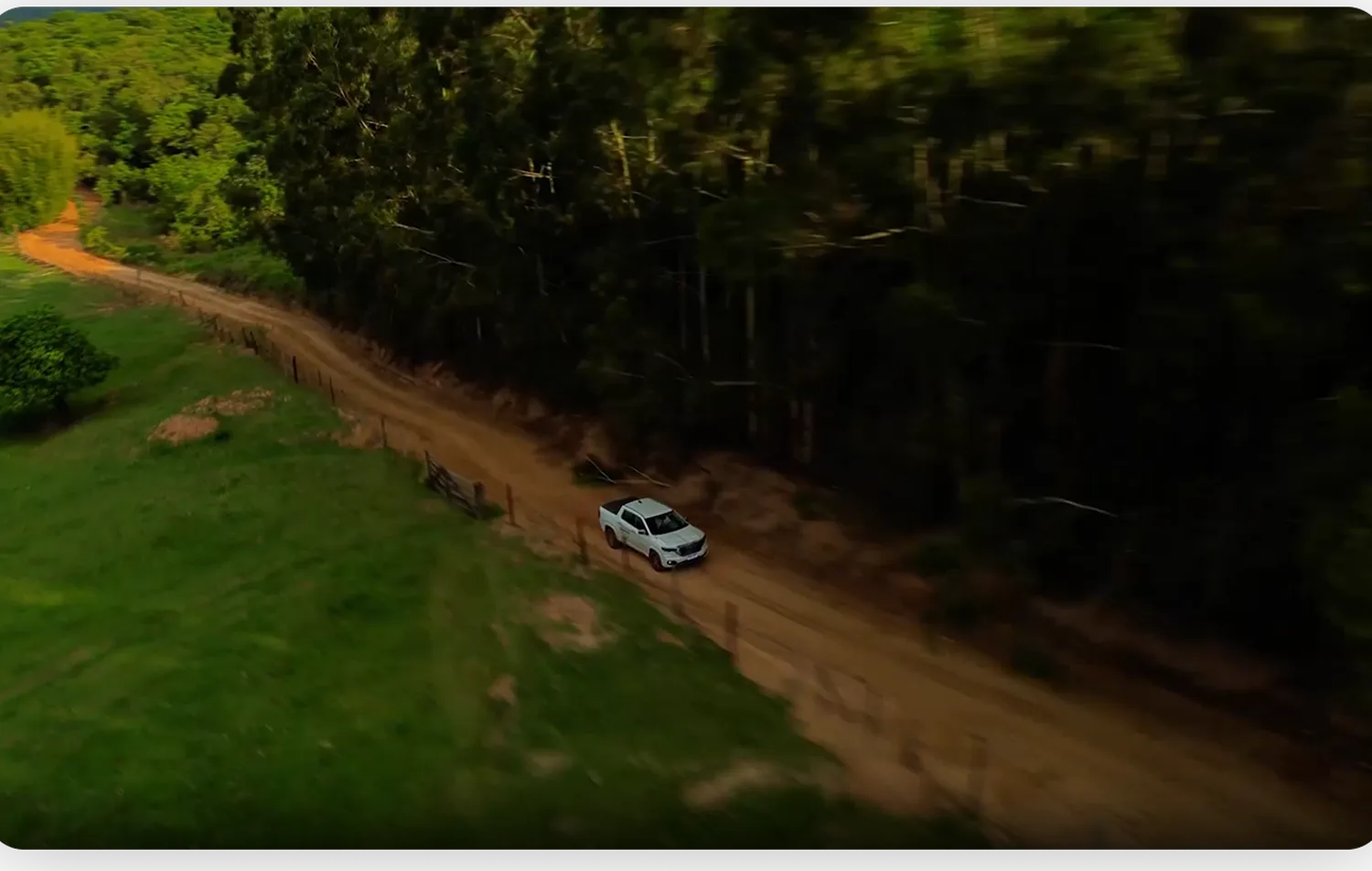 Plano aéreo de drone acompanhando o carro na estrada de terra